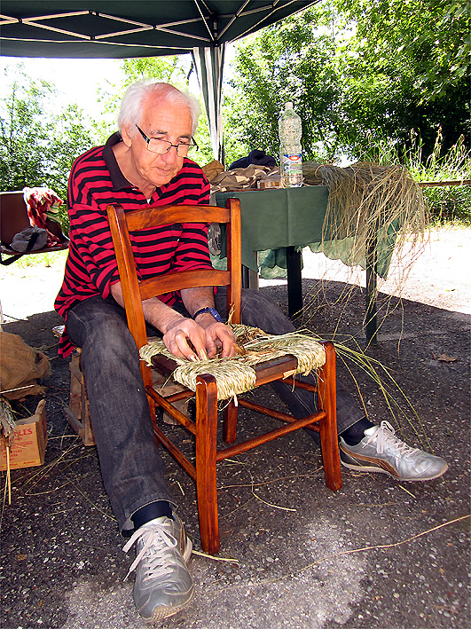 Un artigiano "rinveste" una sedia con il "sarello" (foto Enrico Zarri)
